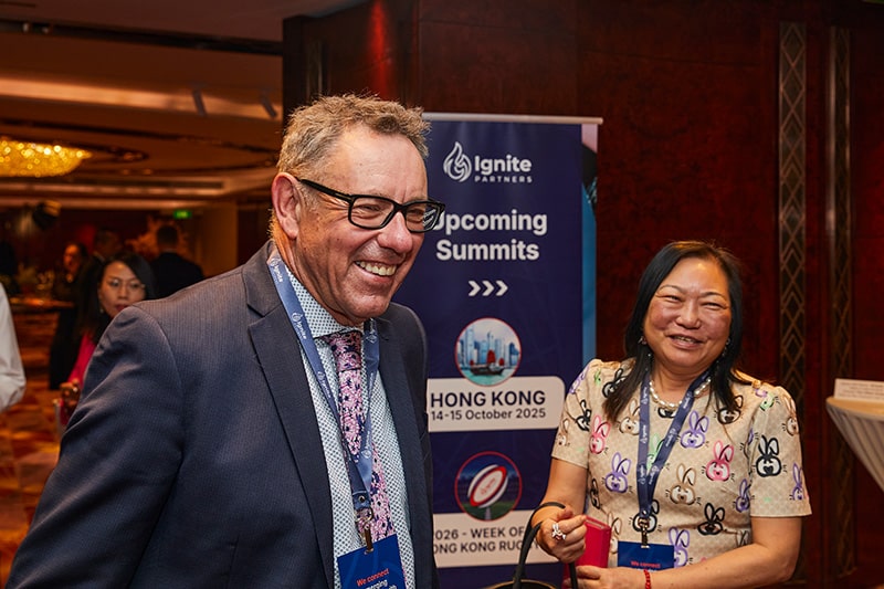 Corporate smiling with investor in background
